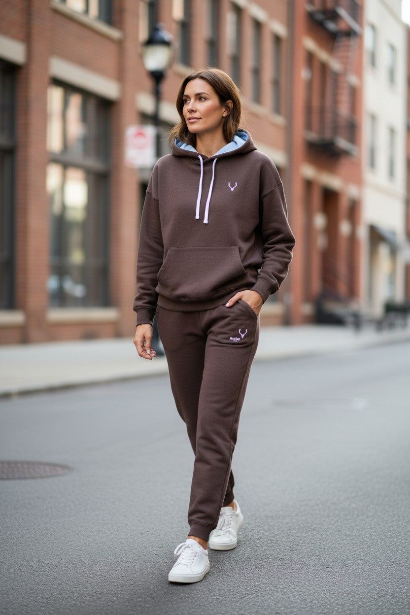 Woman wearing a brown tracksuit with a logo on a city street. Antler, Monza Outlet, Monza Fashion, Shein Outlet
