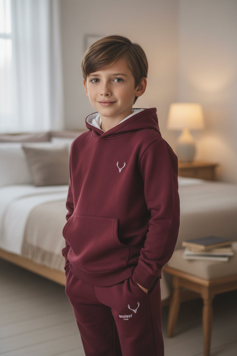 Young boy wearing a maroon hoodie and pants in a bedroom setting. Antler, Monza Outlet, Monza Fashion, Shein Outlet