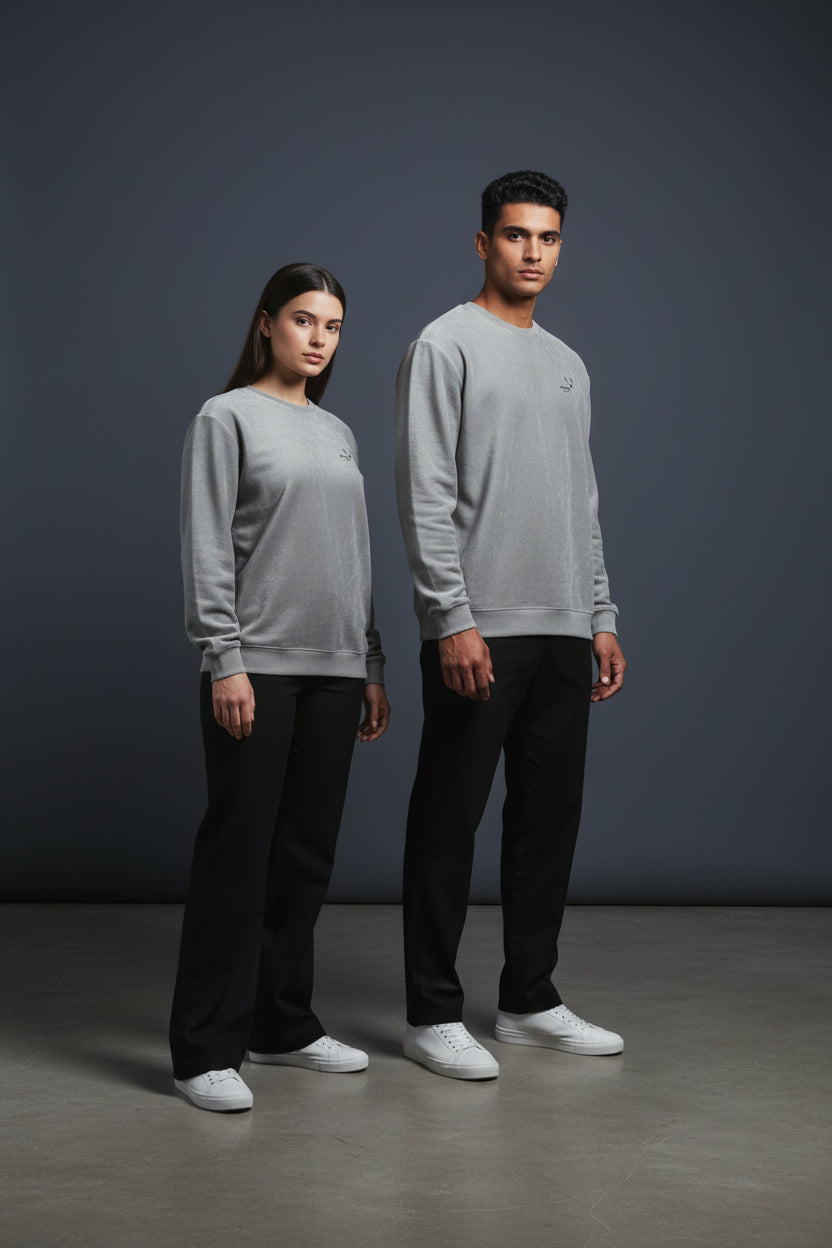 Two people wearing matching gray sweatshirts and black pants on a dark background. Antler, Monza Outlet, Monza Fashion, Shein Outlet