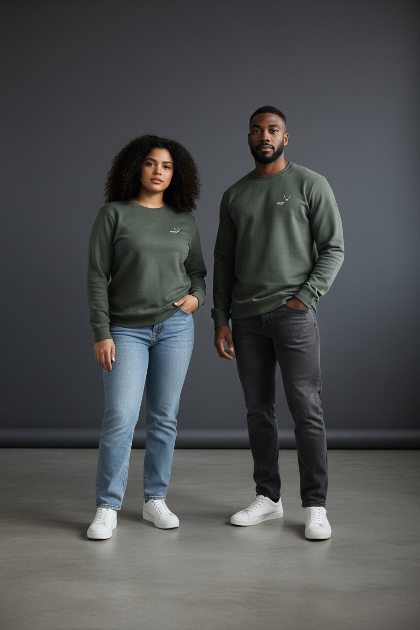 Two people wearing matching green sweatshirts and jeans standing against a gray background. Antler, Monza Outlet, Monza Fashion, Shein Outlet