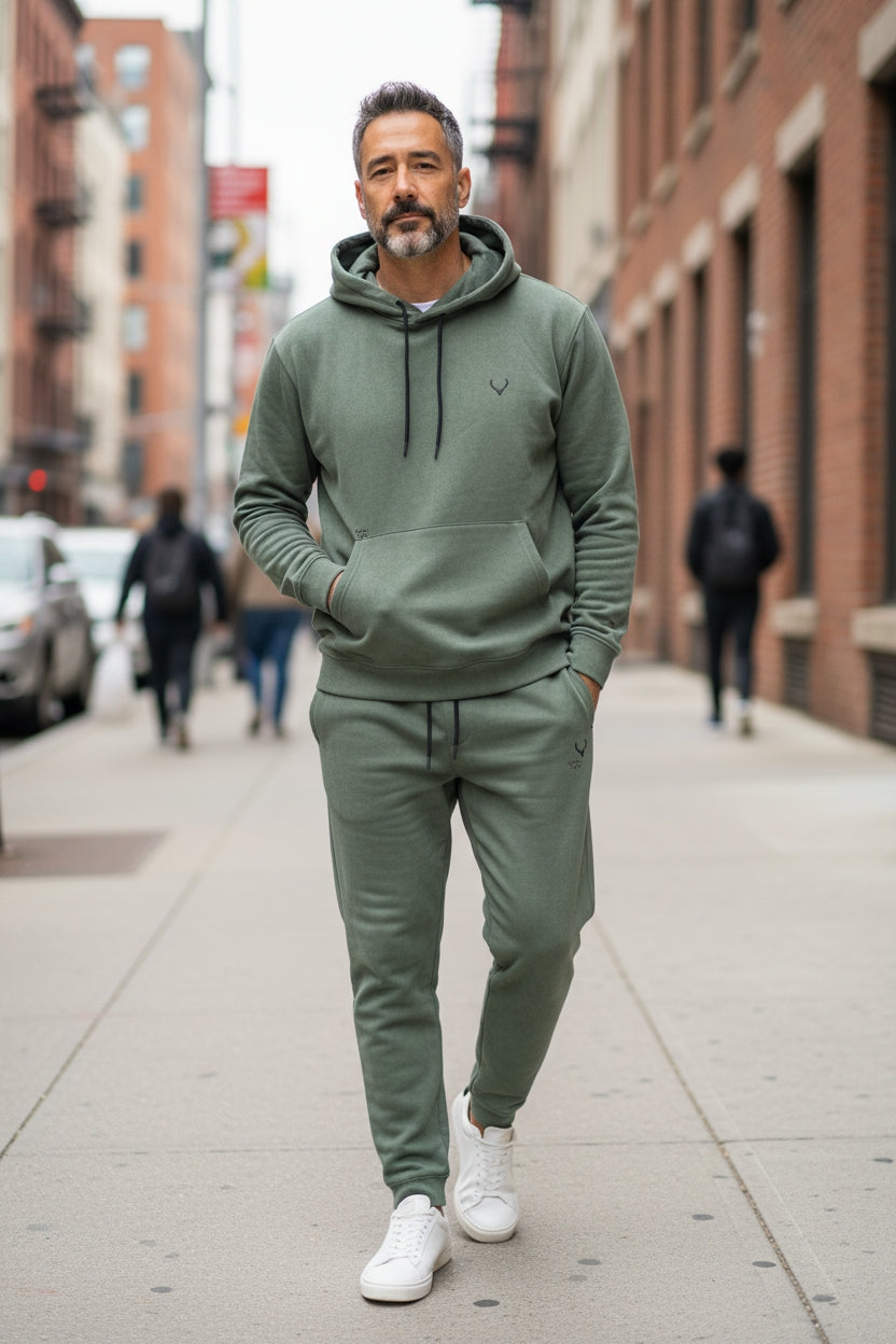 Man wearing a green tracksuit walking on a city street. Antler, Monza Outlet, Monza Fashion, Shein Outlet