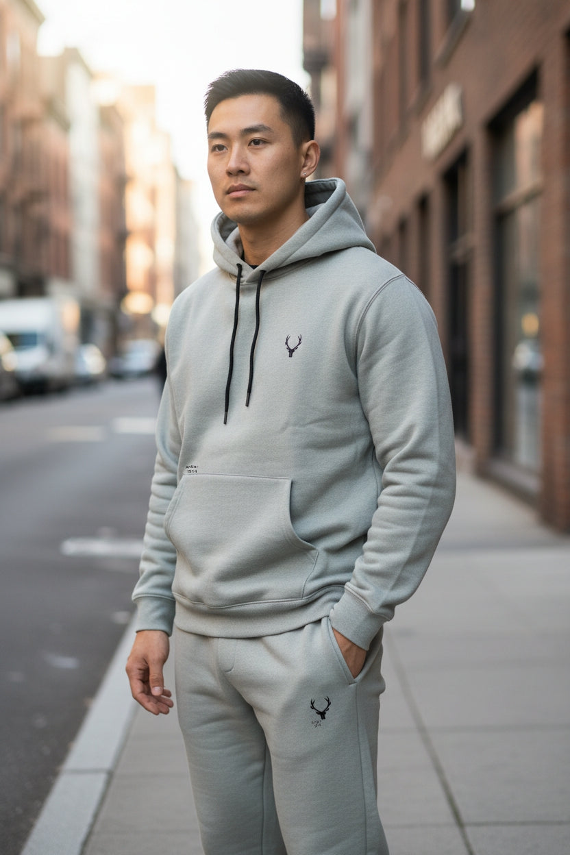 Man wearing a gray hoodie and pants on a city street. Antler, Monza Outlet, Monza Fashion, Shein Outlet