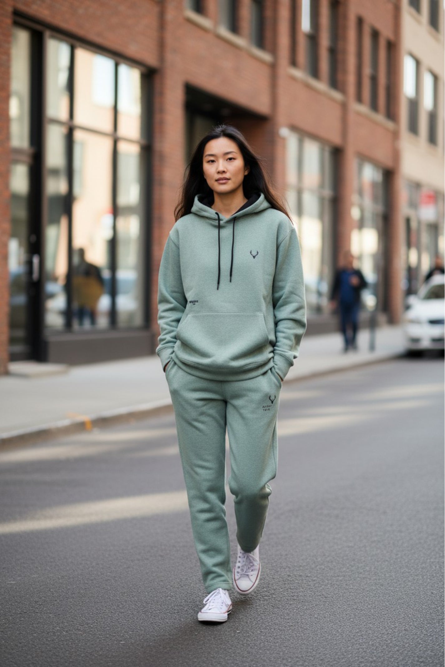 Woman in a green tracksuit walking on a city street. Antler, Monza Outlet, Monza Fashion, Shein Outlet