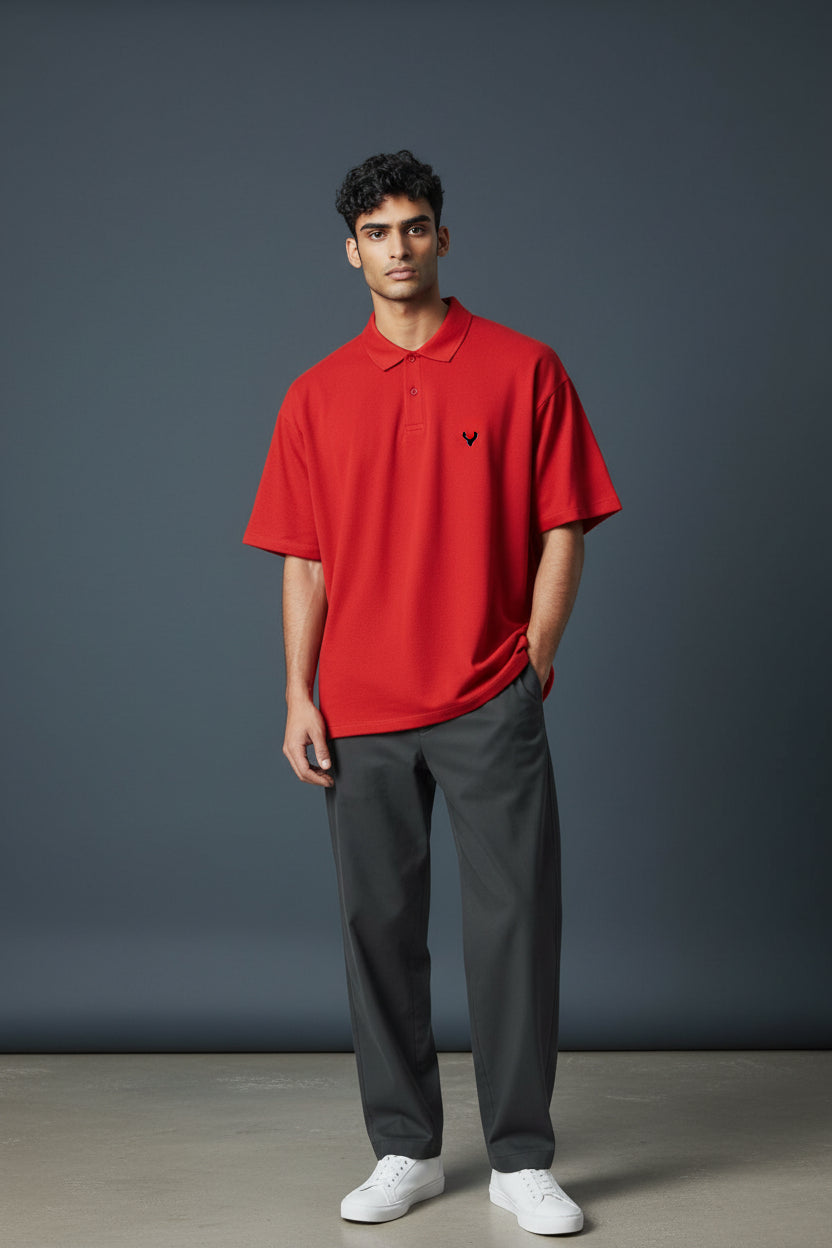 Man wearing a red polo shirt with a small black logo, dark gray pants, and white shoes against a gray background. Antler, Monza Outlet, Monza Fashion, Shein Outlet