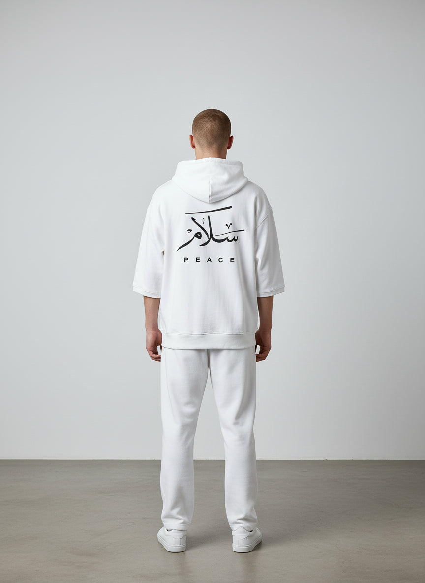 Person wearing a white hoodie with Arabic text and 'PEACE' on the back, standing against a plain background. Antler, Monza Outlet, Monza Fashion, Shein Outlet