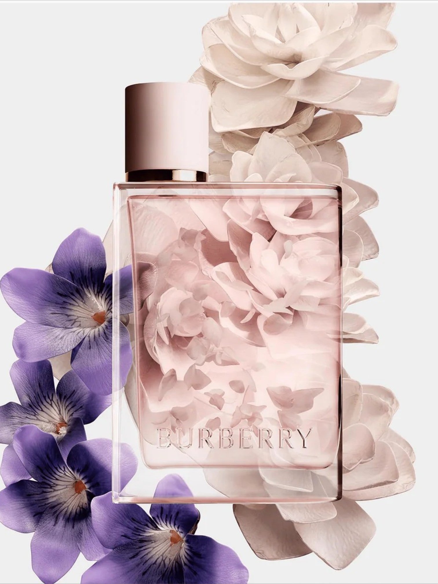 Burberry perfume bottle with floral design and flowers around it on a light background. Burberry, Monza Outlet, Monza Fashion, Shein Outlet