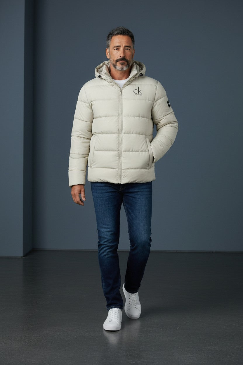 Man wearing a Calvin Klein puffer jacket against a gray background. Calvin Klein, Monza Outlet, Monza Fashion, Shein Outlet