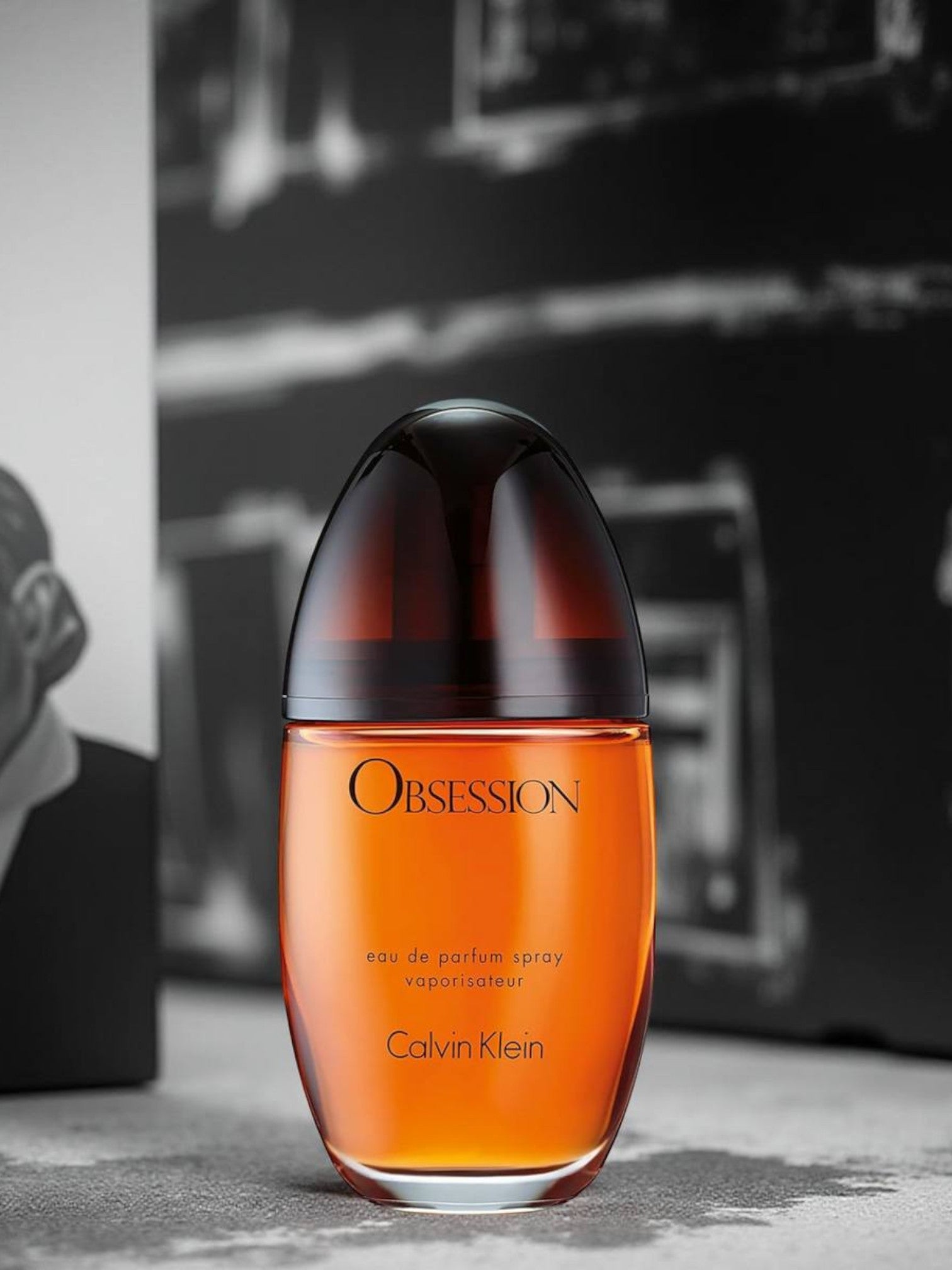 Calvin Klein Obsession perfume bottle on a textured surface with a blurred background. Calvin Klein, Monza Outlet, Monza Fashion, Shein Outlet