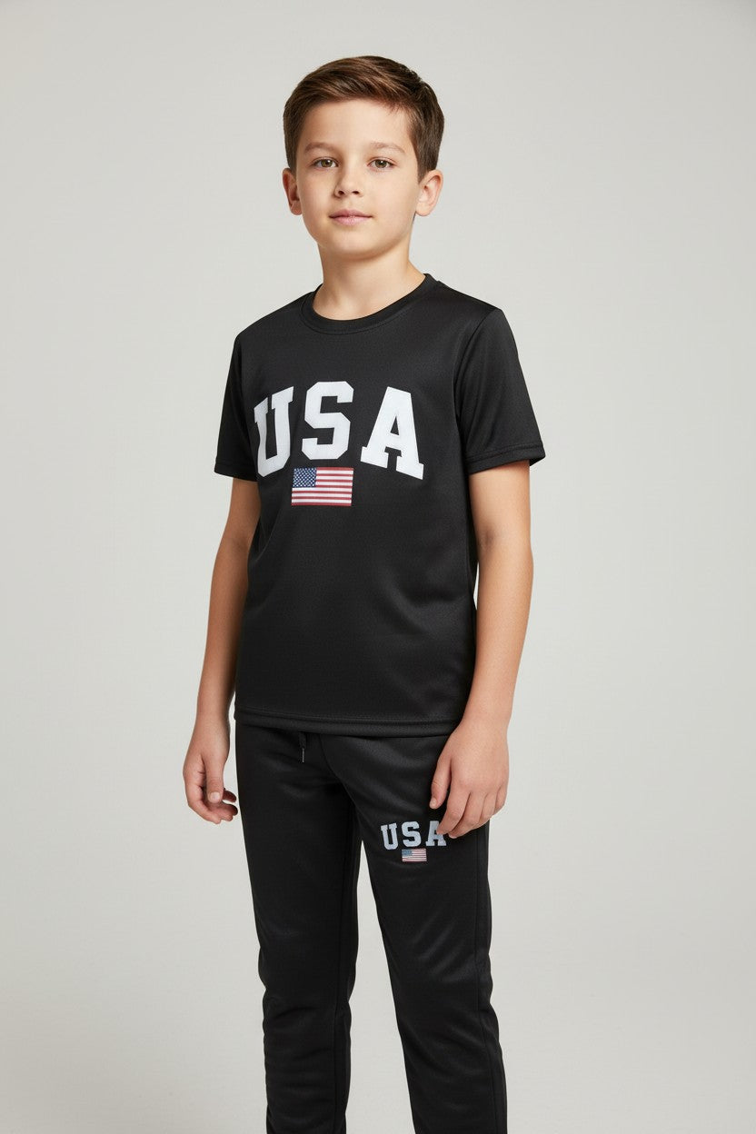 Child wearing a black USA t-shirt and pants with an American flag on a gray background. Antler, Monza Outlet, Monza Fashion, Shein Outlet