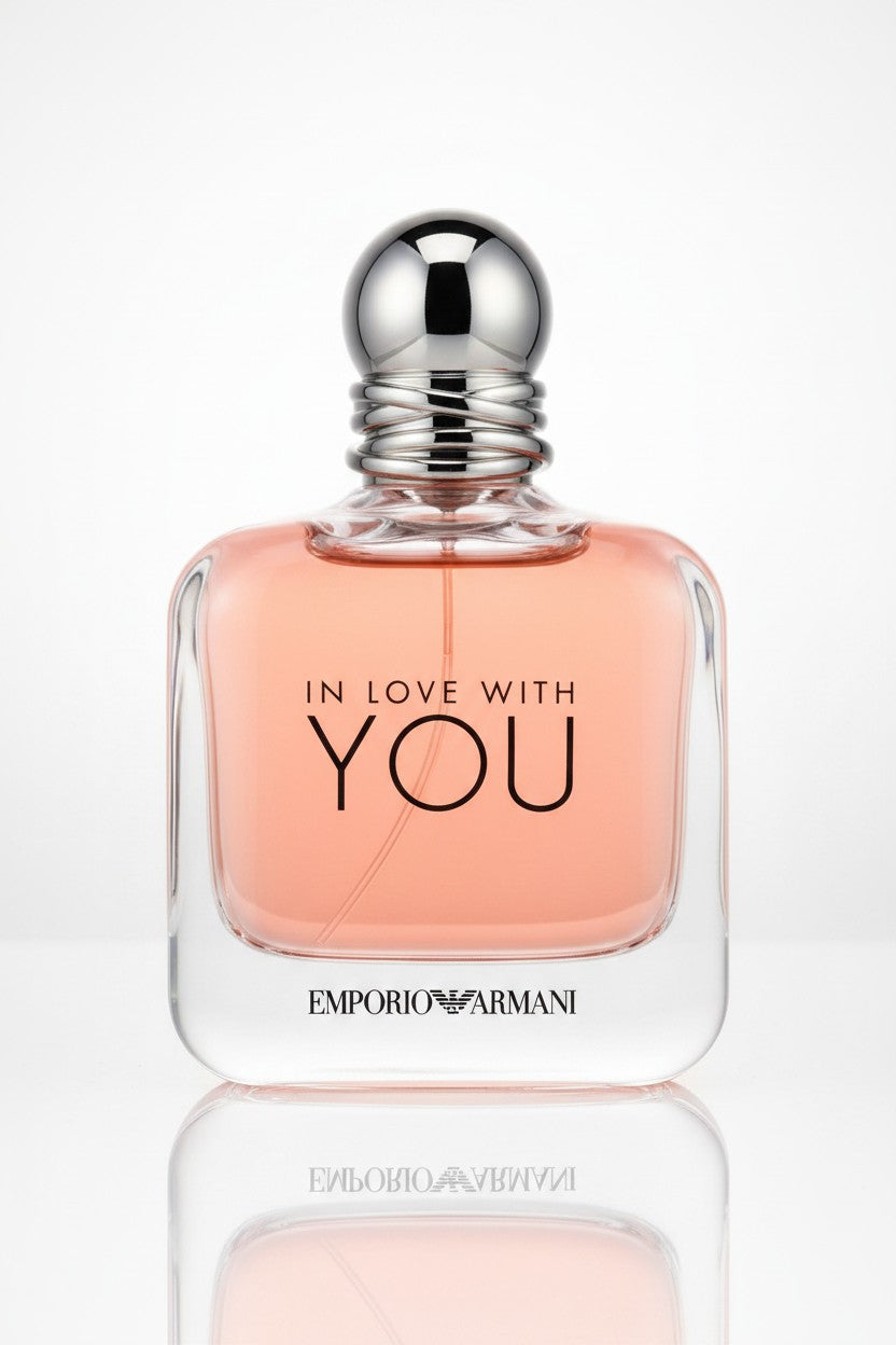 Emporio Armani In Love With You Eau de Toilette perfume bottle, featuring a clear glass body filled with peach-colored liquid, a silver metallic cap, and black lettering, set against a clean white background with a soft reflection below. Emporio Armani, Monza Outlet, Monza Fashion, Shein Outlet