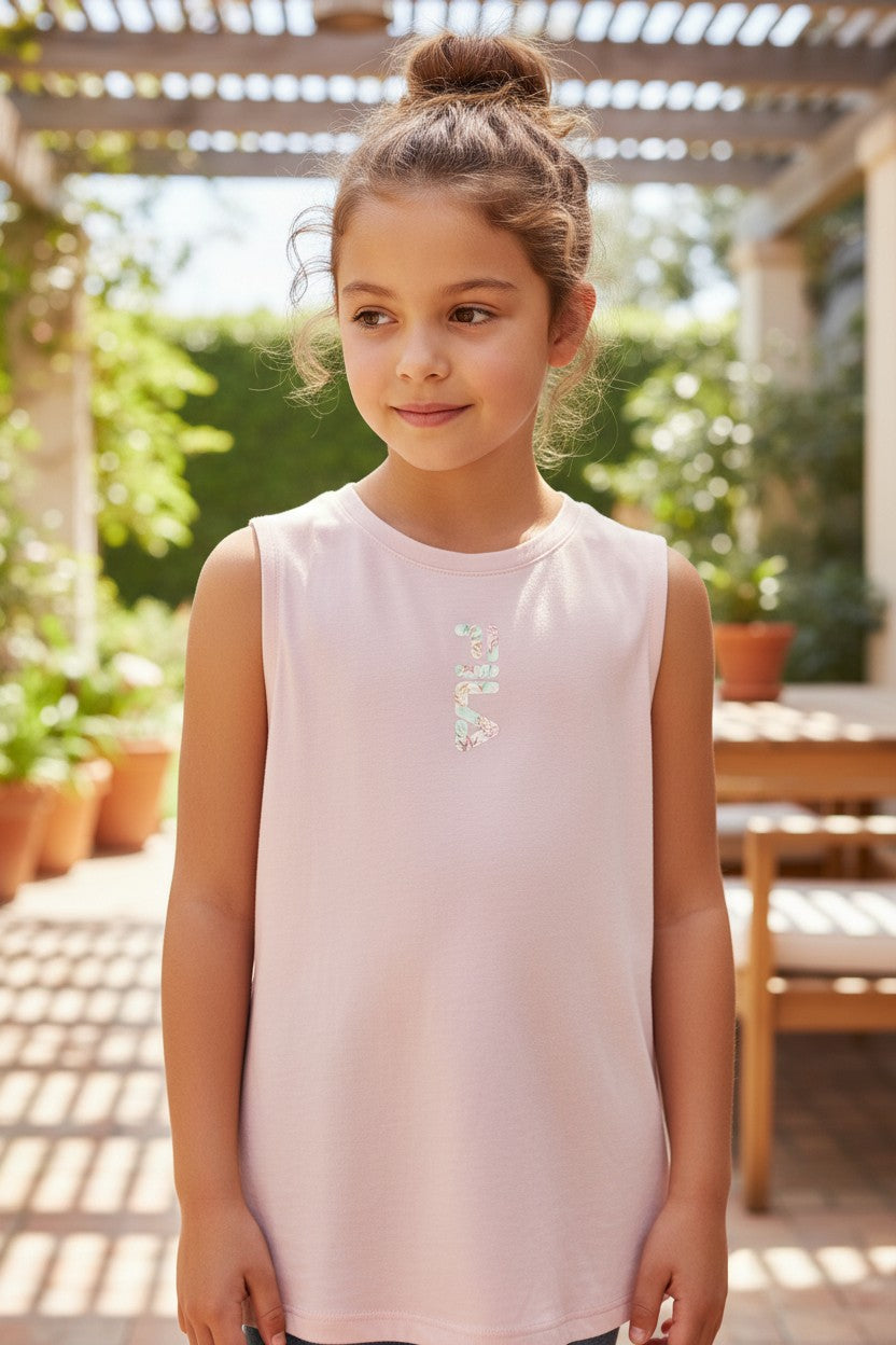 Young girl wearing a light pink sleeveless top with a decorative element, standing outdoors. Fila, Monza Outlet, Monza Fashion, Shein Outlet