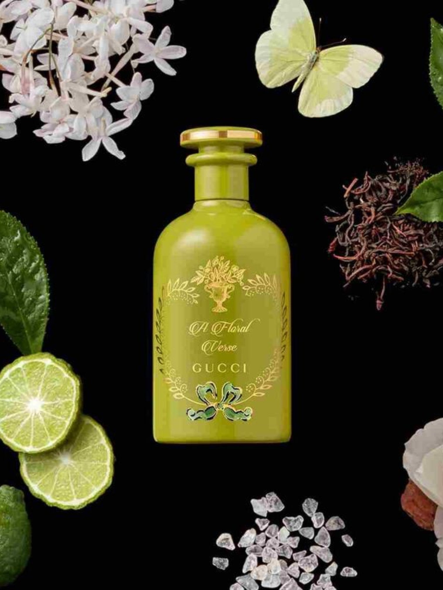 Green Gucci floral perfume bottle surrounded by flowers and leaves on a black background. Gucci, Monza Outlet, Monza Fashion, Shein Outlet