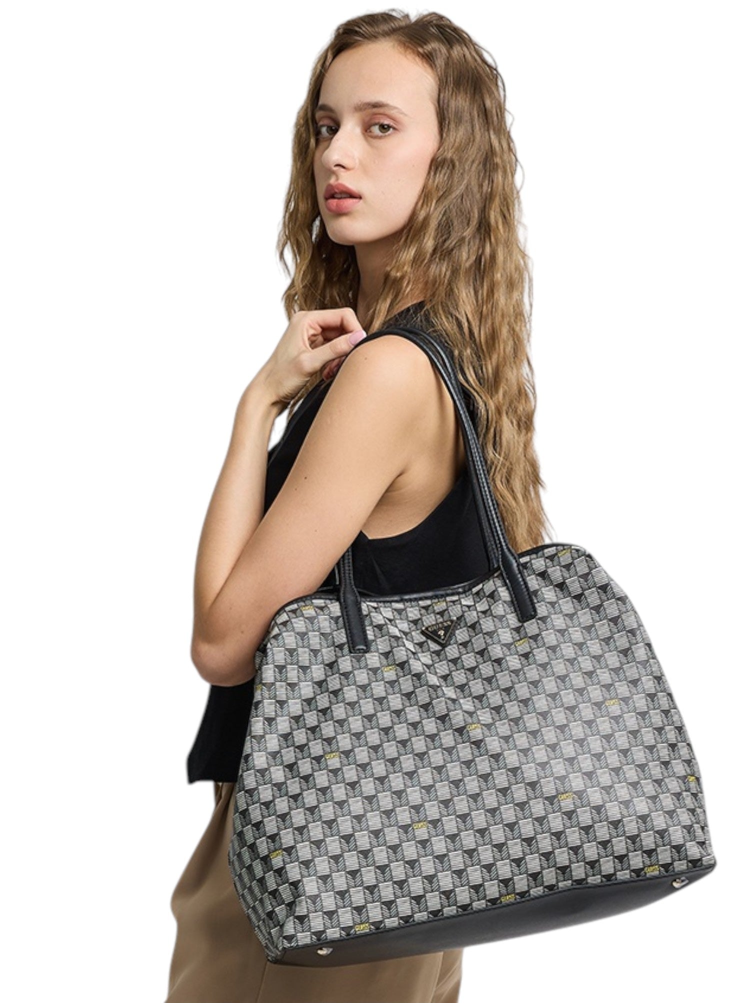 Woman holding a patterned tote bag against a white background. Guess, Monza Outlet, Monza Fashion, Shein Outlet