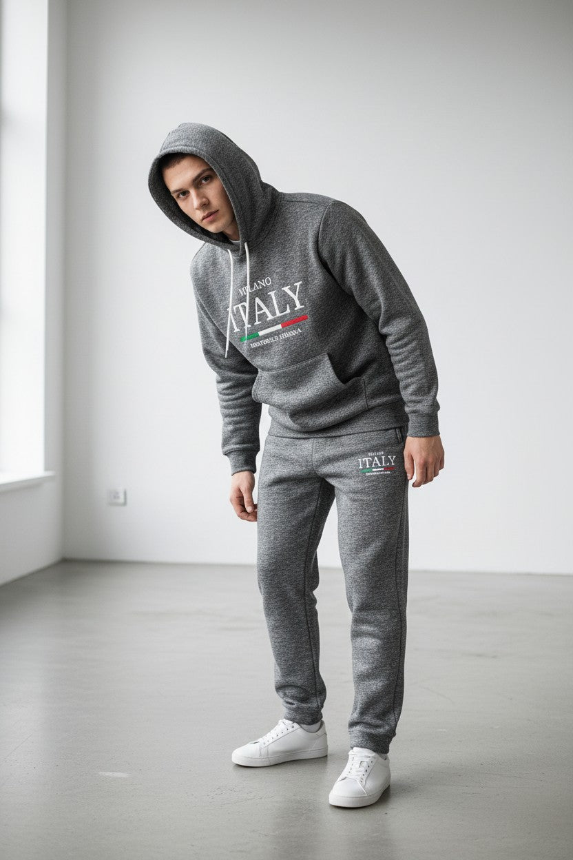 Person wearing a gray ITALY hoodie and sweatpants in a minimalistic room. Antler, Monza Outlet, Monza Fashion, Shein Outlet