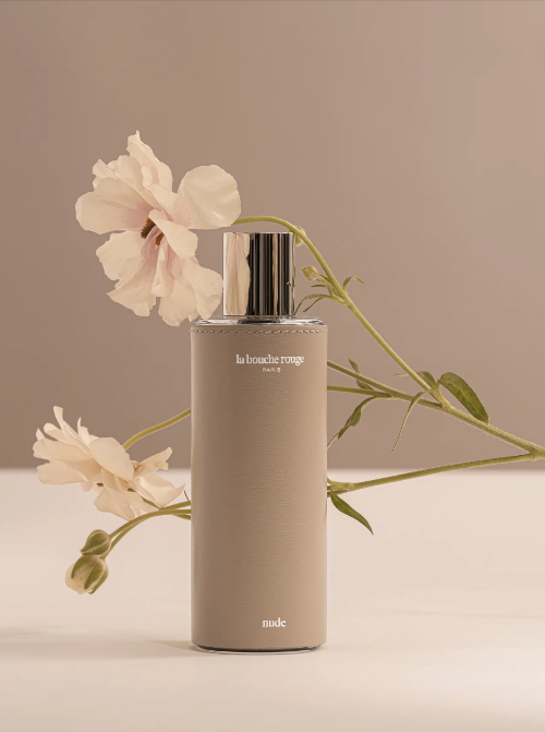 Beige bottle with floral arrangement on a beige background