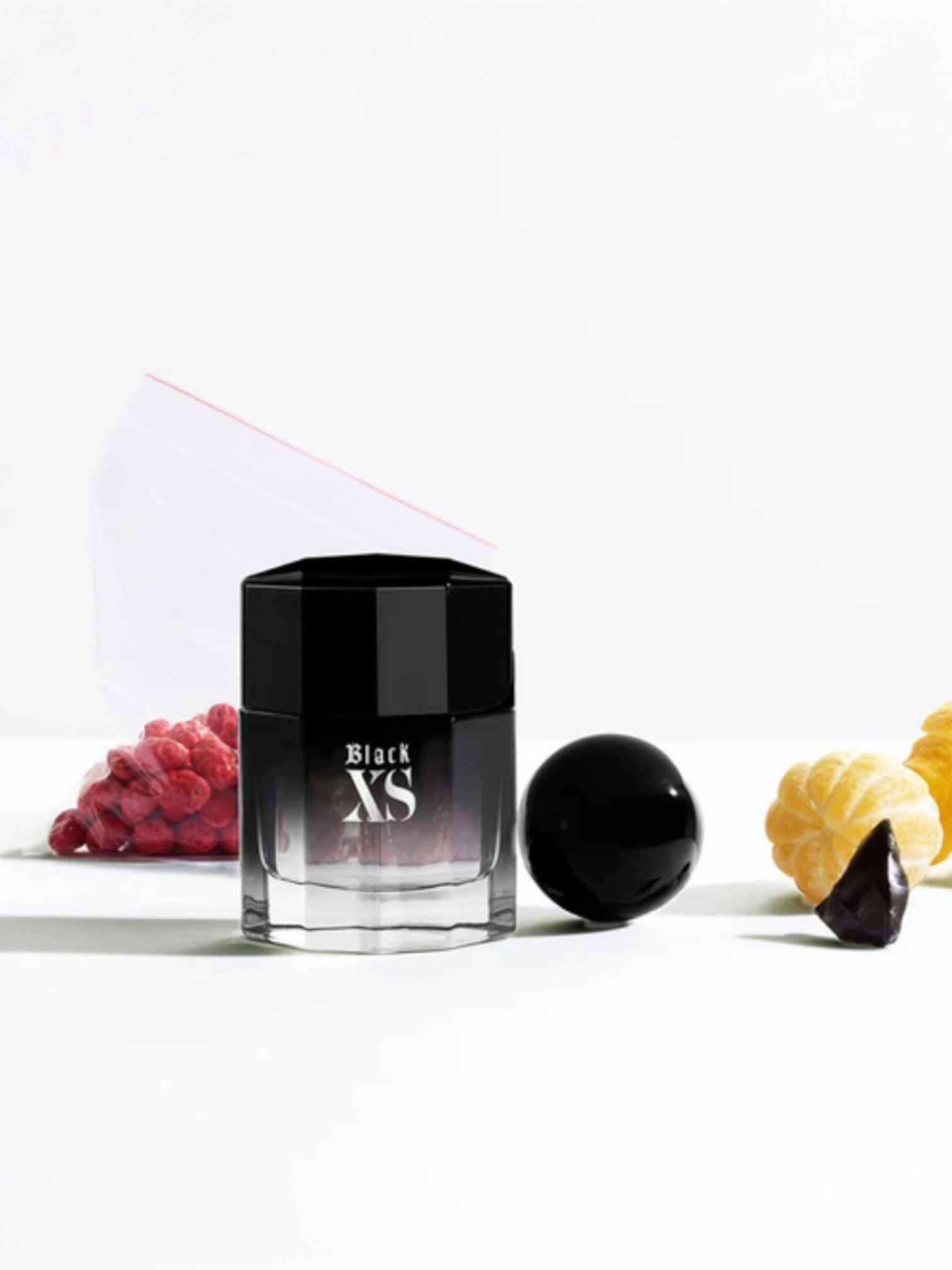 Black XS perfume bottle with fruits on a white background. Paco Rabanne, Monza Outlet, Monza Fashion, Shein Outlet