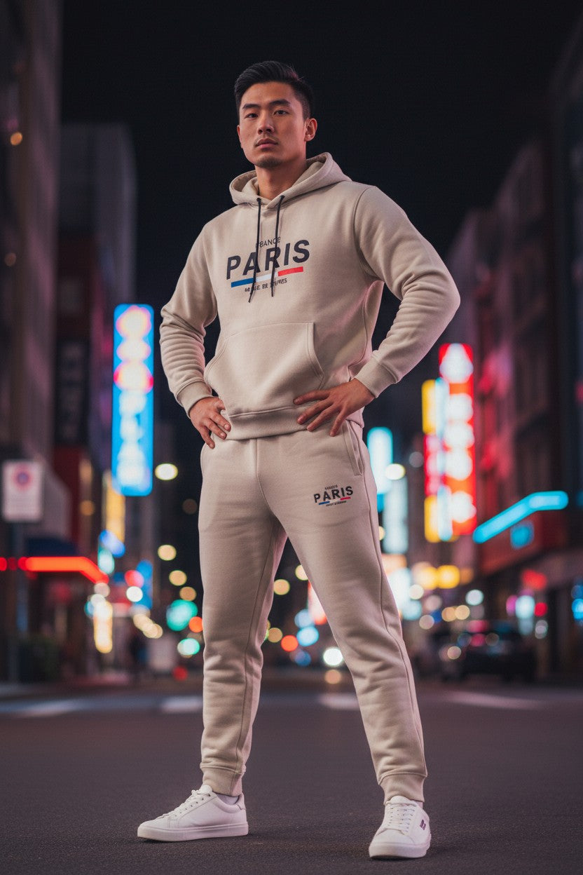 Person wearing a PARIS hoodie and pants on a city street at night. Antler, Monza Outlet, Monza Fashion, Shein Outlet