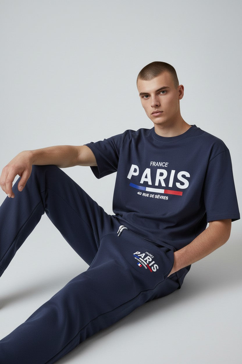 Person wearing a navy blue Paris t-shirt and pants on a light gray background. Antler, Monza Outlet, Monza Fashion, Shein Outlet