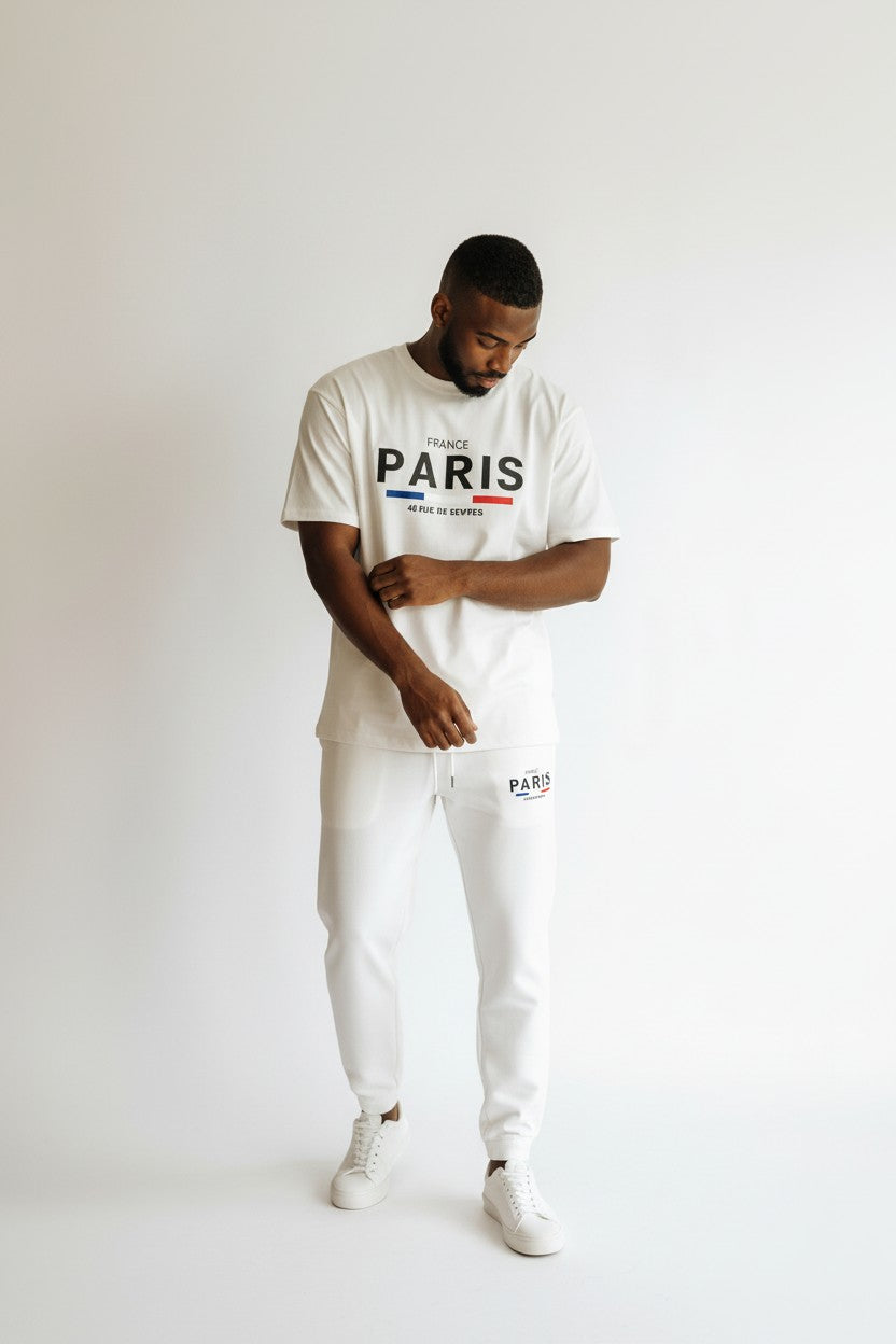 Man wearing a white t-shirt with Paris print and white pants on a plain background. Antler, Monza Outlet, Monza Fashion, Shein Outlet