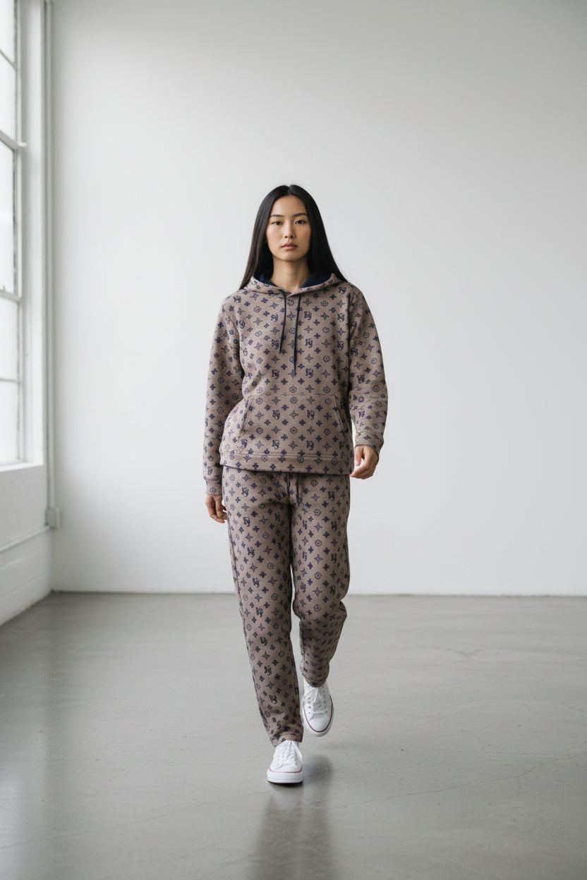 Person wearing a patterned hoodie and pants set in a minimalistic room. Antler, Monza Outlet, Monza Fashion, Shein Outlet