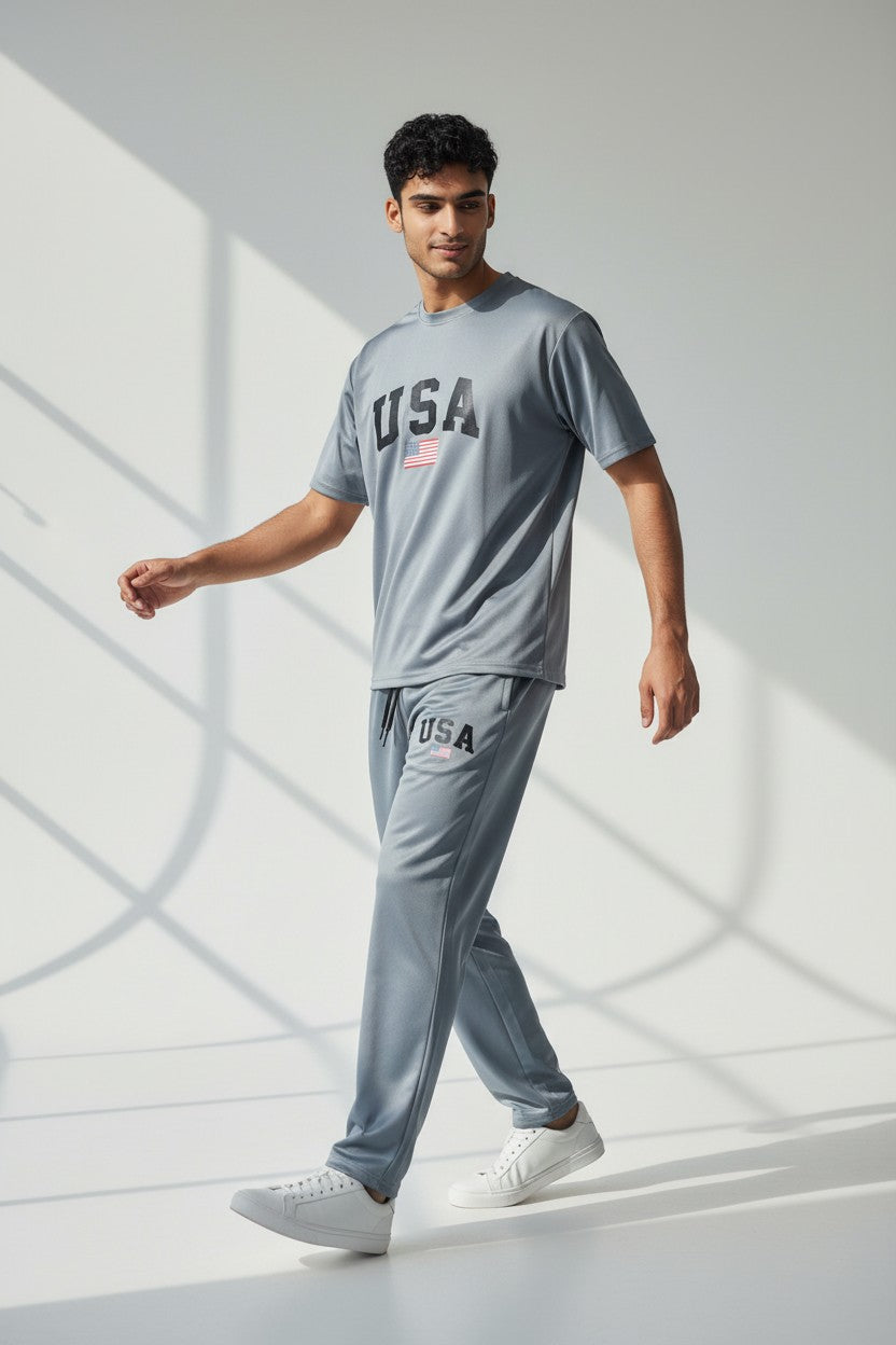 Man wearing a gray USA t-shirt and pants walking on a light background. Antler, Monza Outlet, Monza Fashion, Shein Outlet