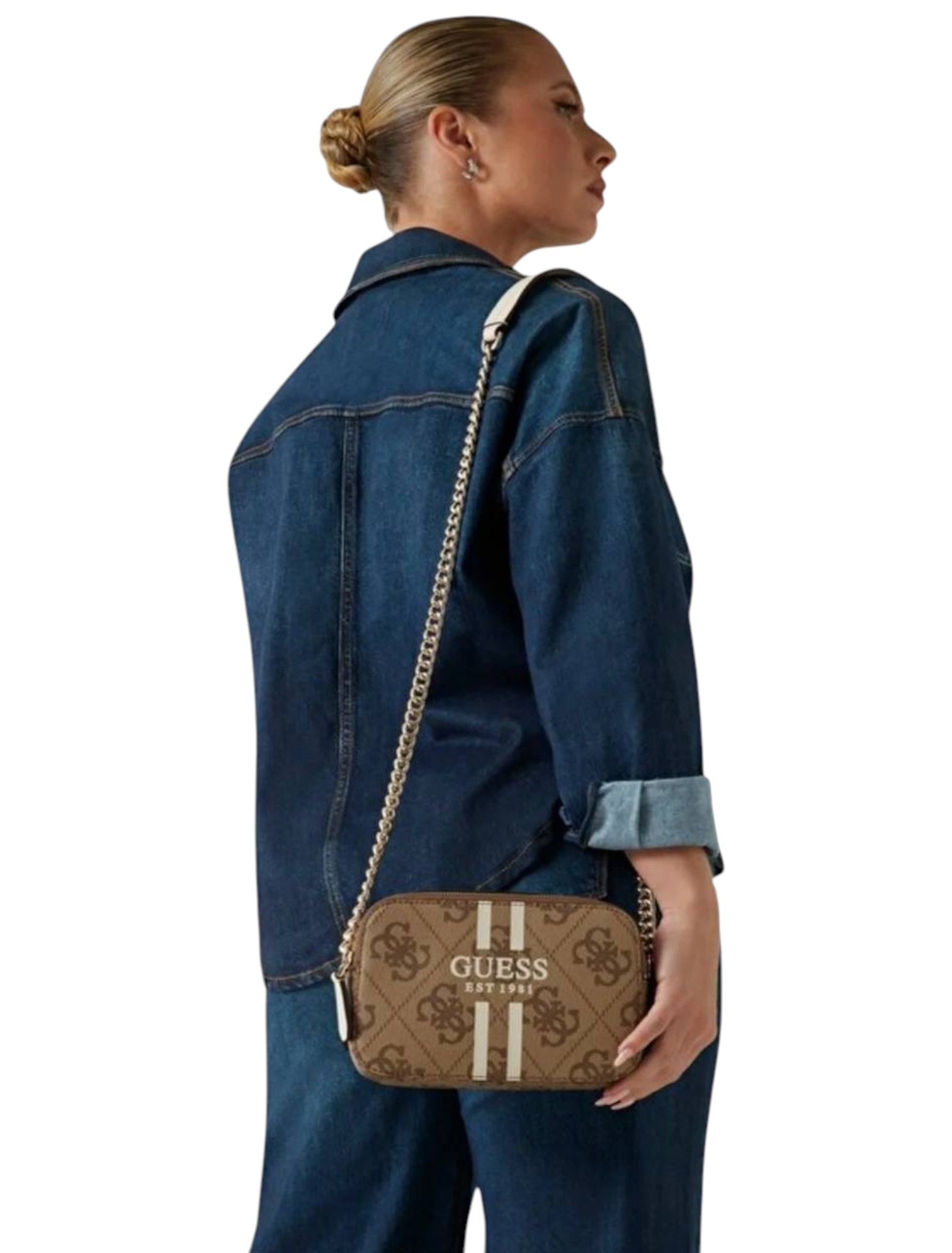 Person wearing a denim jacket with a Guess handbag over their shoulder on a white background. Guess, Monza Outlet, Monza Fashion, Shein Outlet