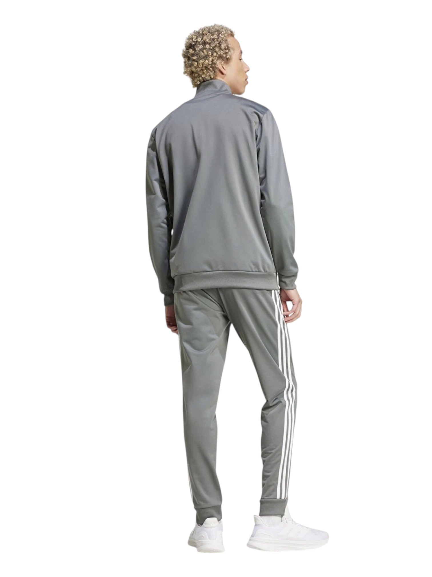 Person wearing a gray tracksuit with white stripes on a white background. Adidas, Monza Outlet, Monza Fashion, Shein Outlet
