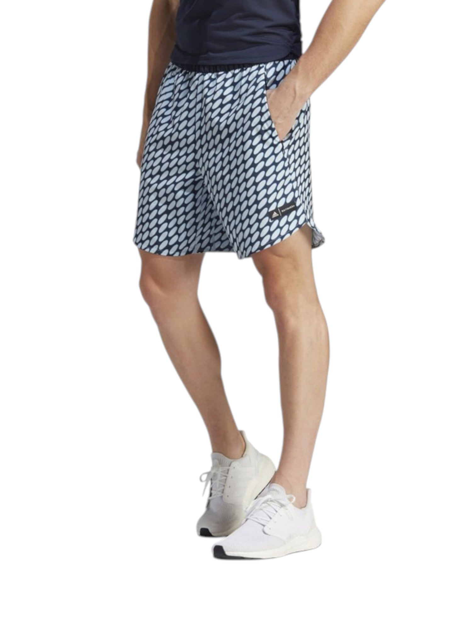 Person wearing a patterned skirt and white sneakers on a white background. Adidas, Monza Outlet, Monza Fashion, Shein Outlet
