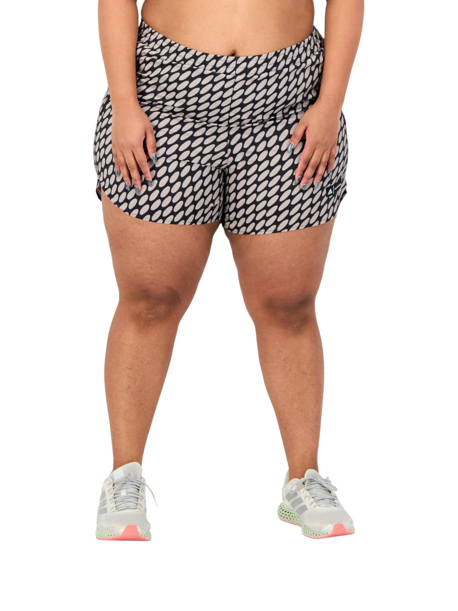Person wearing black and white patterned shorts on a white background. Adidas, Monza Outlet, Monza Fashion, Shein Outlet