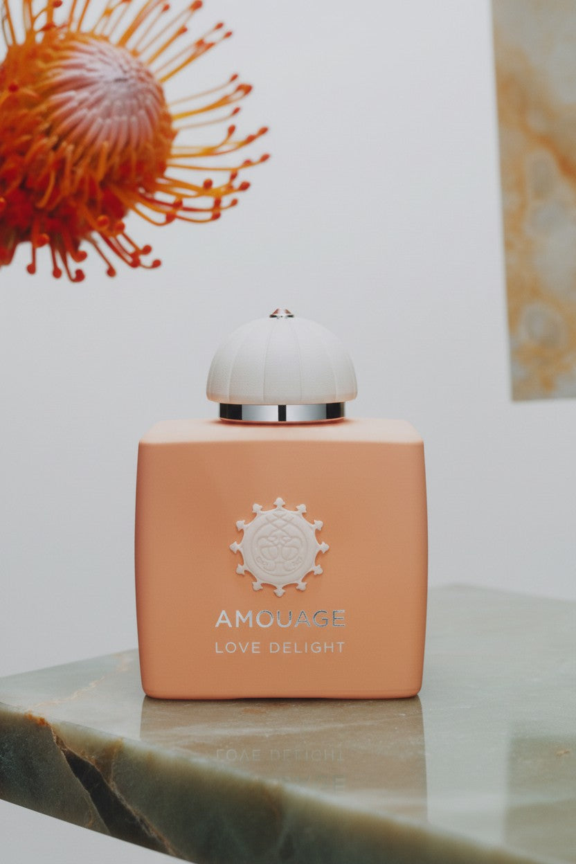 Pink perfume bottle labeled Amouage Love Delight on a marble surface with a blurred background. Amouage, Monza Outlet, Monza Fashion, Shein Outlet