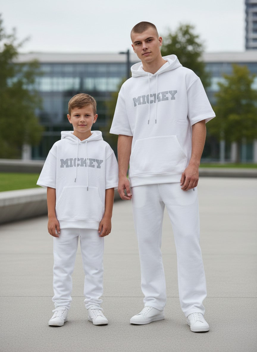 Two individuals wearing matching white outfits with 'MICKEY' text, standing outdoors. Antler, Monza Outlet, Monza Fashion, Shein Outlet
