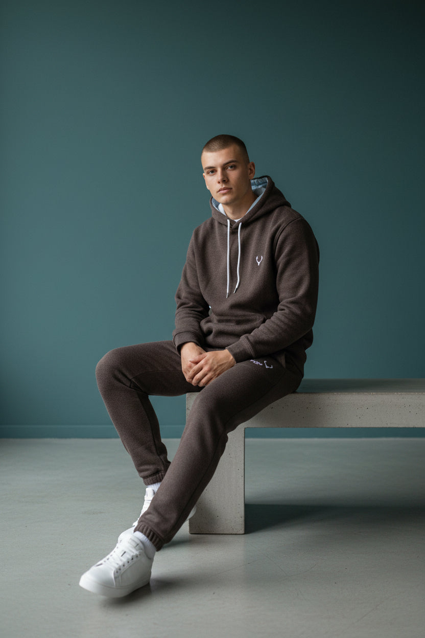 Man sitting on a concrete block against a teal wall. Antler, Monza Outlet, Monza Fashion, Shein Outlet