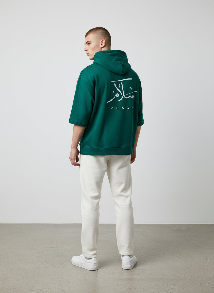 Person wearing a green hoodie with a logo on the back against a white background. Antler, Monza Outlet, Monza Fashion, Shein Outlet