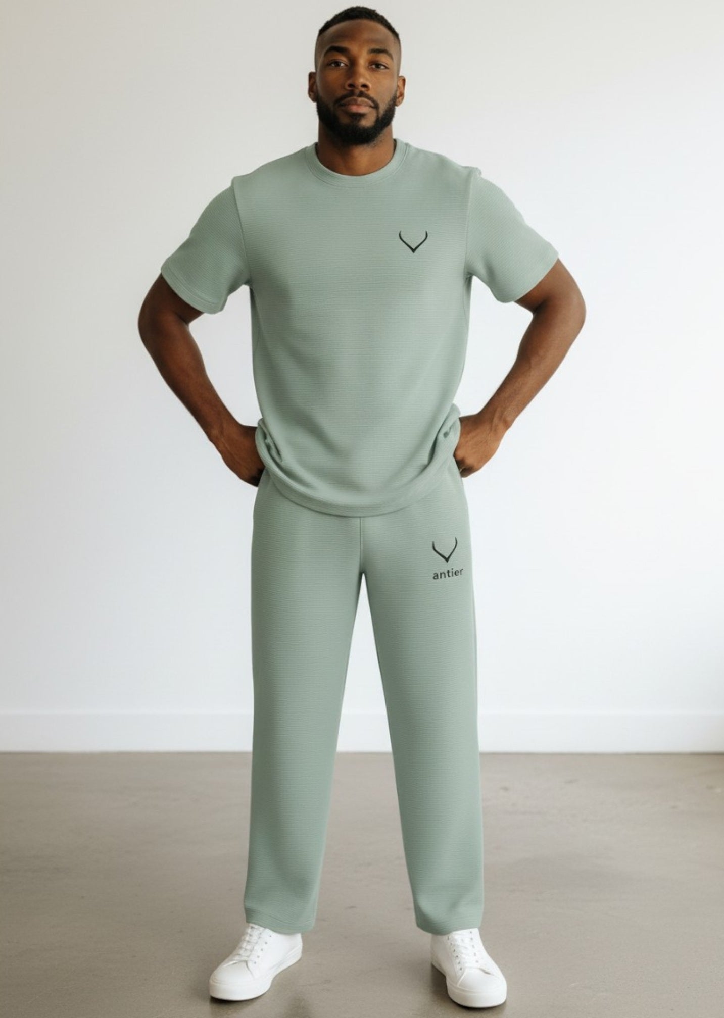 Man wearing a matching green t-shirt and pants with a logo, standing against a plain background. Antler, Monza Outlet, Monza Fashion, Shein Outlet