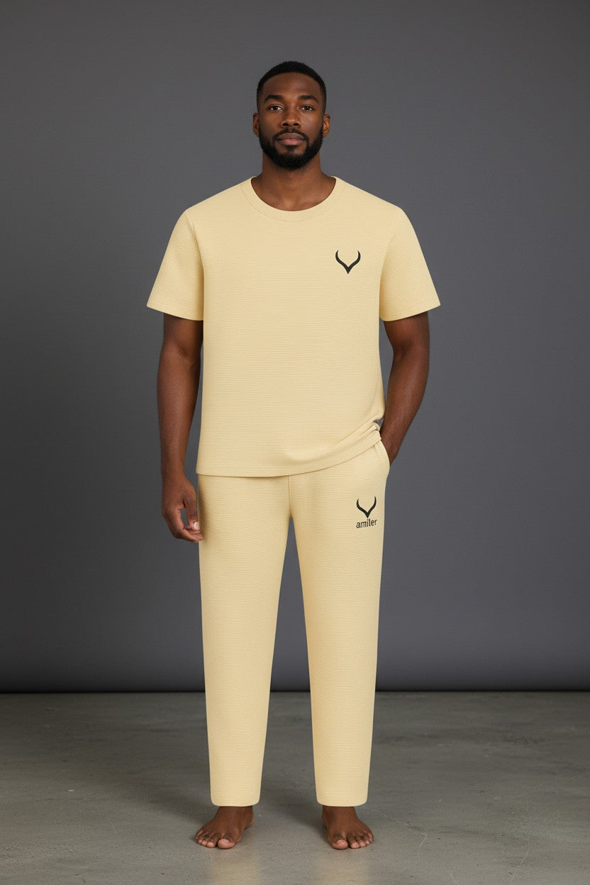 Man wearing a beige t-shirt and pants with a logo on a gray background. Antler, Monza Outlet, Monza Fashion, Shein Outlet
