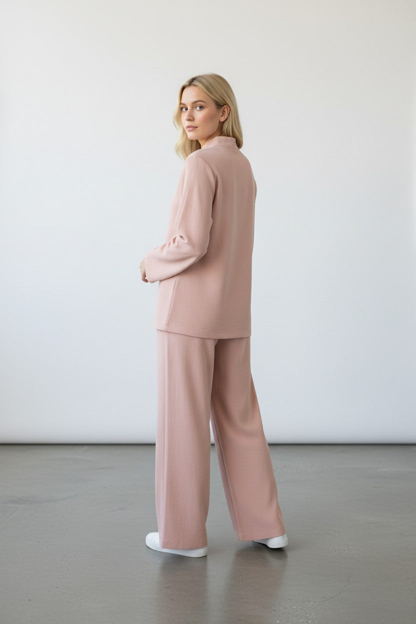 Woman wearing a pink outfit standing against a white wall. Antler, Monza Outlet, Monza Fashion, Shein Outlet