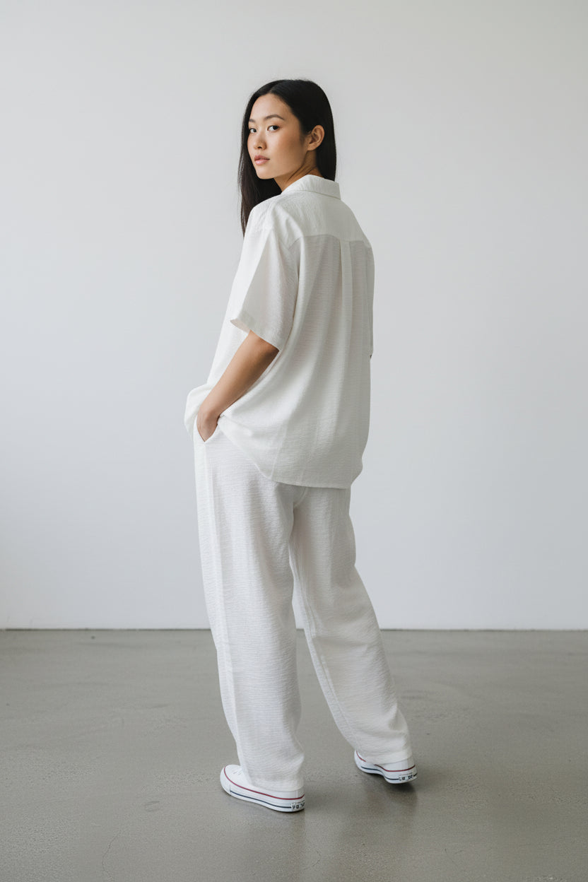 Person wearing a white outfit standing against a plain background. Antler, Monza Outlet, Monza Fashion, Shein Outlet