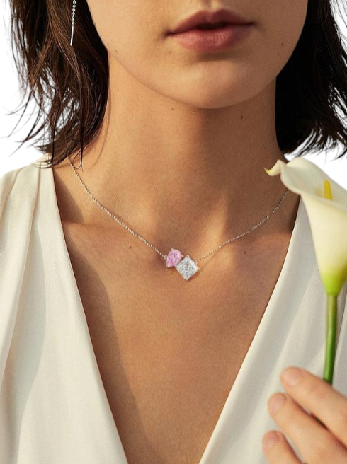 Necklace with a heart-shaped pendant worn by a person holding a white flower. monza outlet, Shein outlet, monza fashion