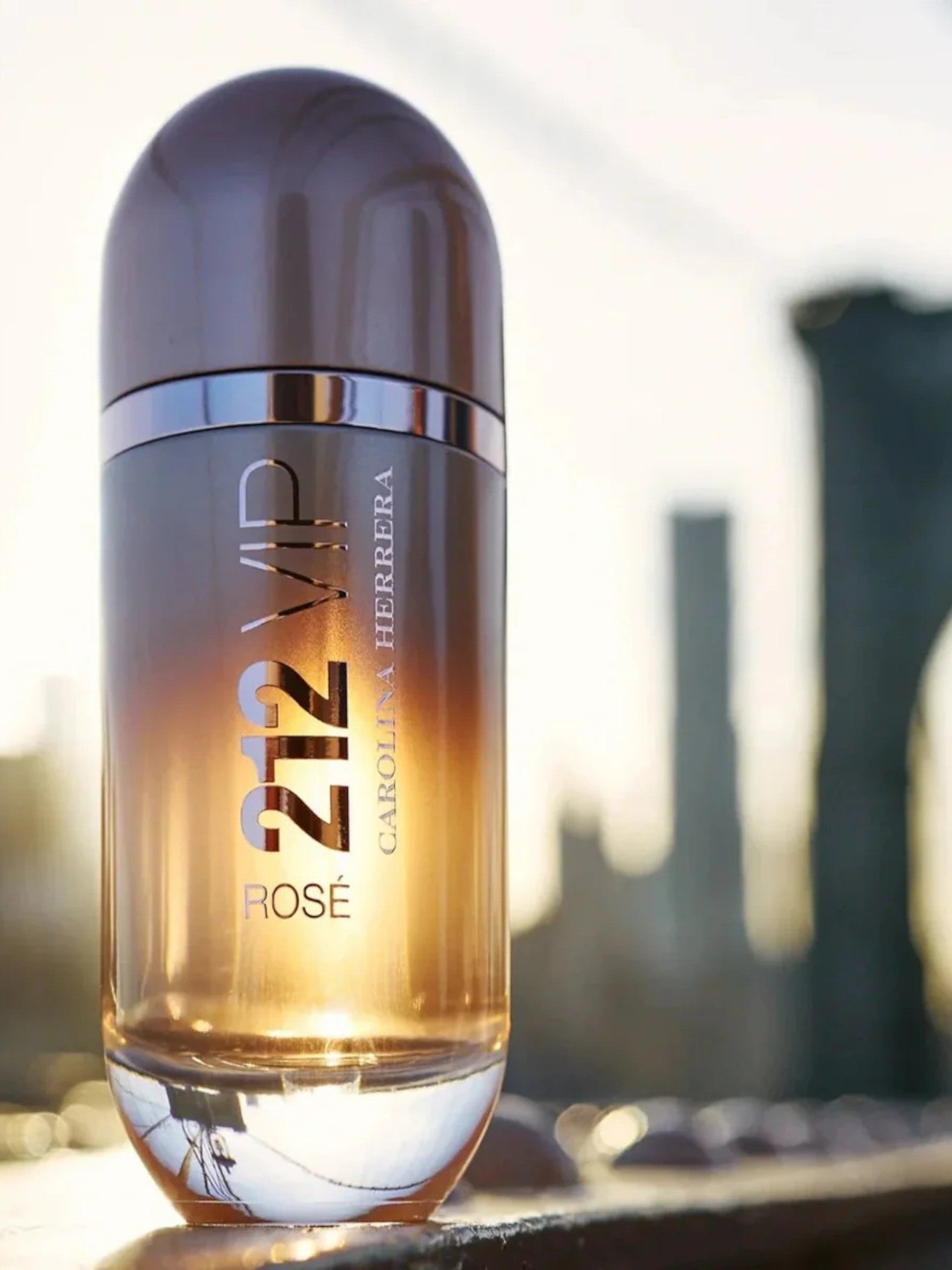 Perfume bottle labeled 212 VIP Rose by Carolina Herrera on a blurred cityscape background. Carolina Herrera, Monza Outlet, Monza Fashion, Shein Outlet
