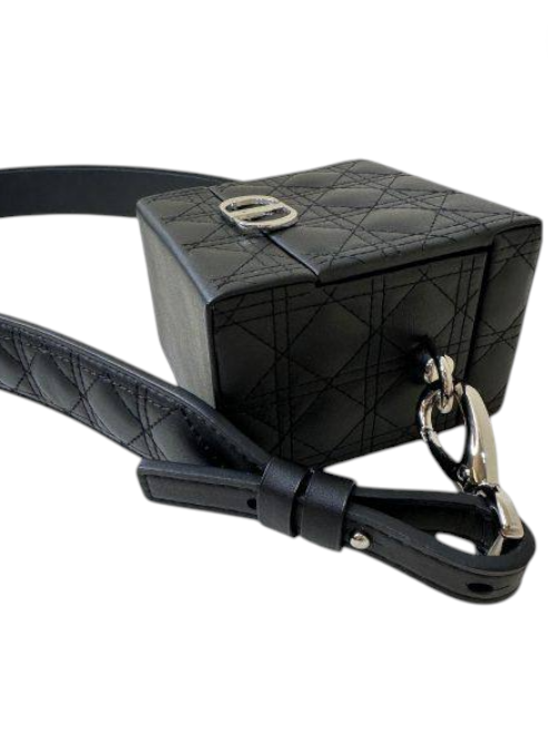 Black quilted handbag with a strap on a white background. Dior Monza Outlet