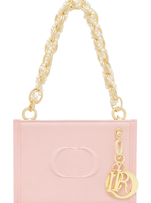 Pink handbag with gold chain handle and LR charm on a white background. Dior Monza Outlet