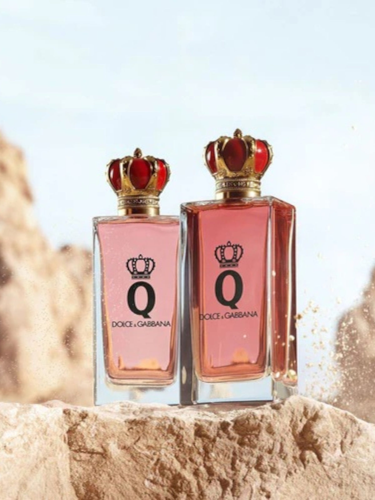 Two Dolce & Gabbana perfume bottles with crowns on a rocky surface. Dolce Gabbana Monza Outlet