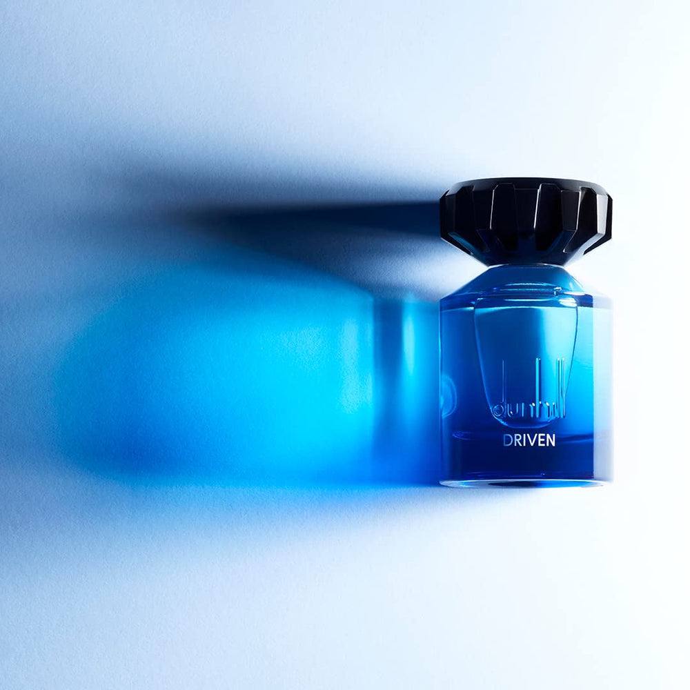 Blue perfume bottle labeled 'Driven' on a light blue background Monza Outlet