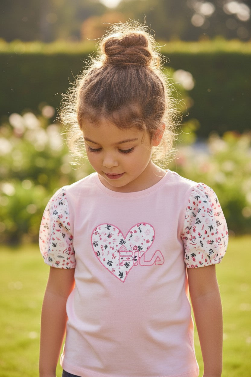 Young girl wearing a pink shirt with a floral heart design outdoors. Fila, Monza Outlet, Monza Fashion, Shein Outlet