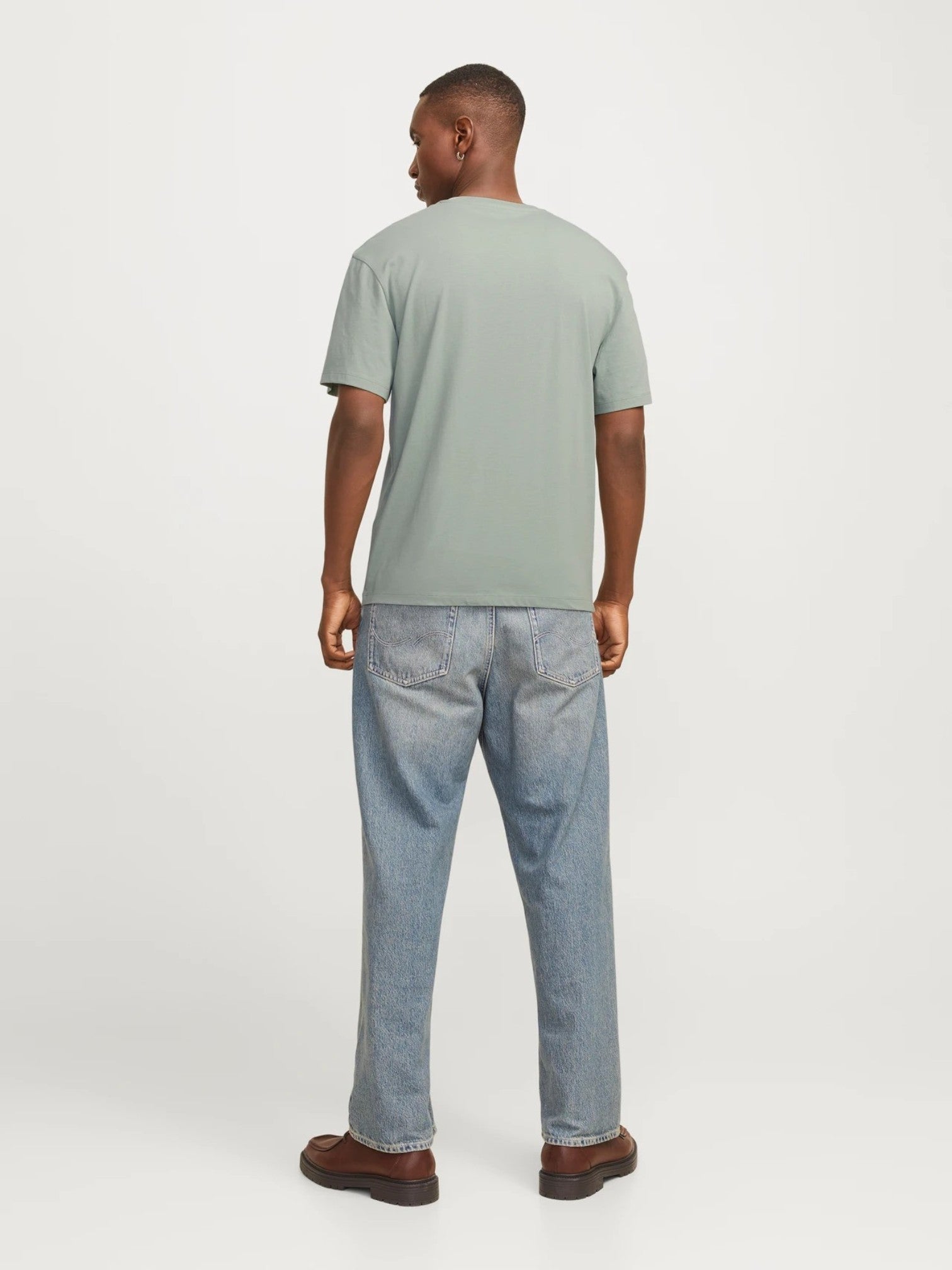 Man wearing a green t-shirt and blue jeans on a white background. Lee, Monza Outlet, Monza Fashion, Shein Outlet