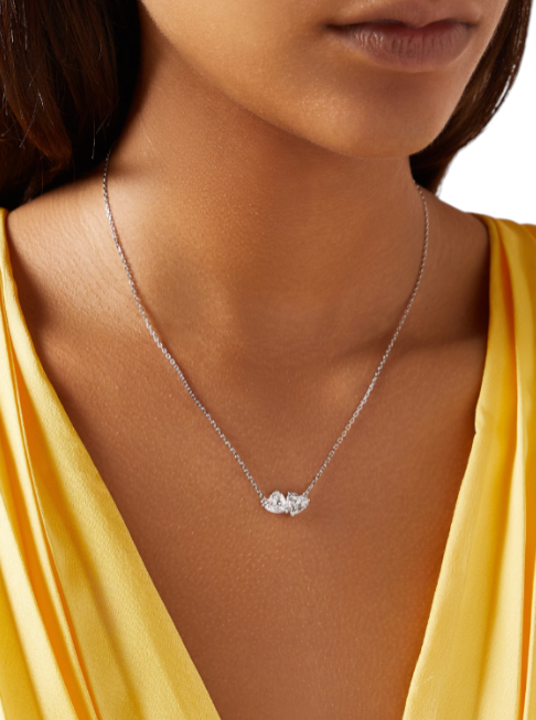 Necklace with a pendant worn by a person in a yellow top on a white background monza outlet, Shein outlet, monza fashion