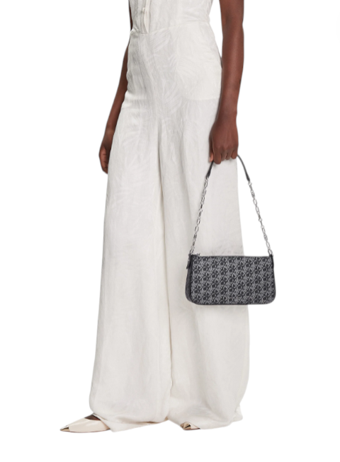 Person holding a black and white patterned handbag against a white background Michael Kors Monza Outlet