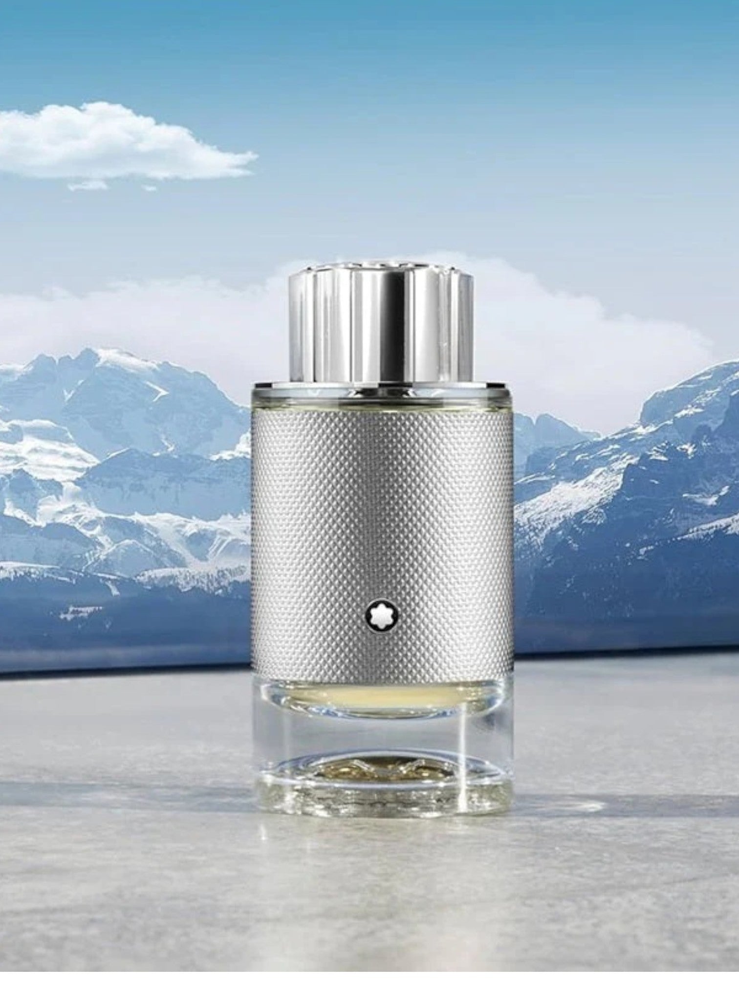 Silver cylindrical product with textured design on a reflective surface with mountain background monza outlet, Shein outlet, monza fashion