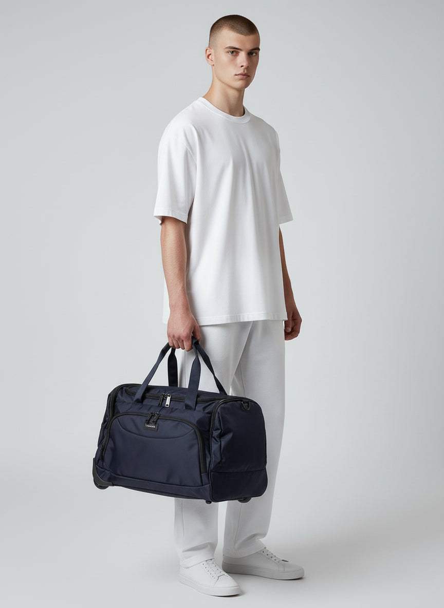 Man holding a navy duffel bag against a plain background. Monza Italy, Monza Outlet, Monza Fashion, Shein Outlet