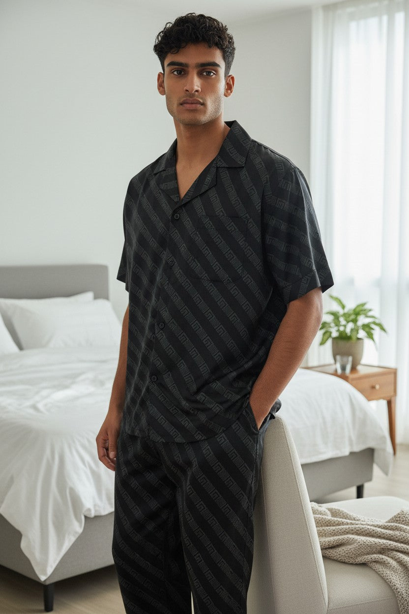 Man wearing black striped pajamas in a bedroom setting. Monza Italy, Monza Outlet, Monza Fashion, Shein Outlet